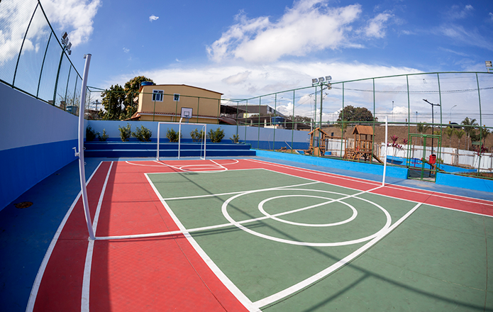 Pessoas jogando basquete em quadra poliesportiva pública na orla